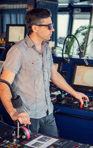 a captain steering a container ship - Transportation & Logistics