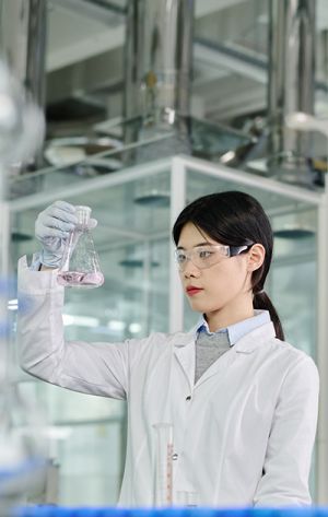 woman holding up an erlenmeyer flask